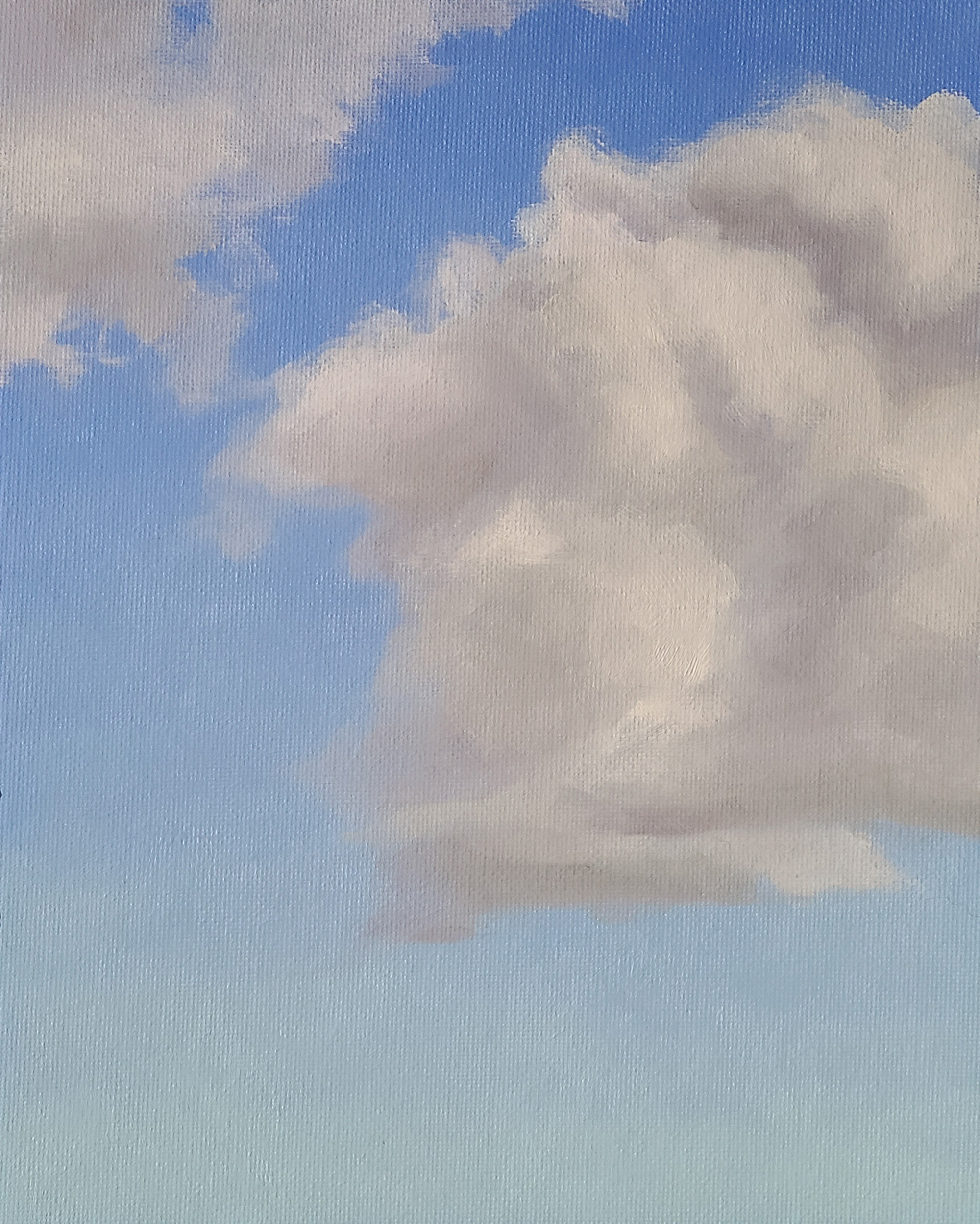 two fluffy cumulus clouds against a light blue sky