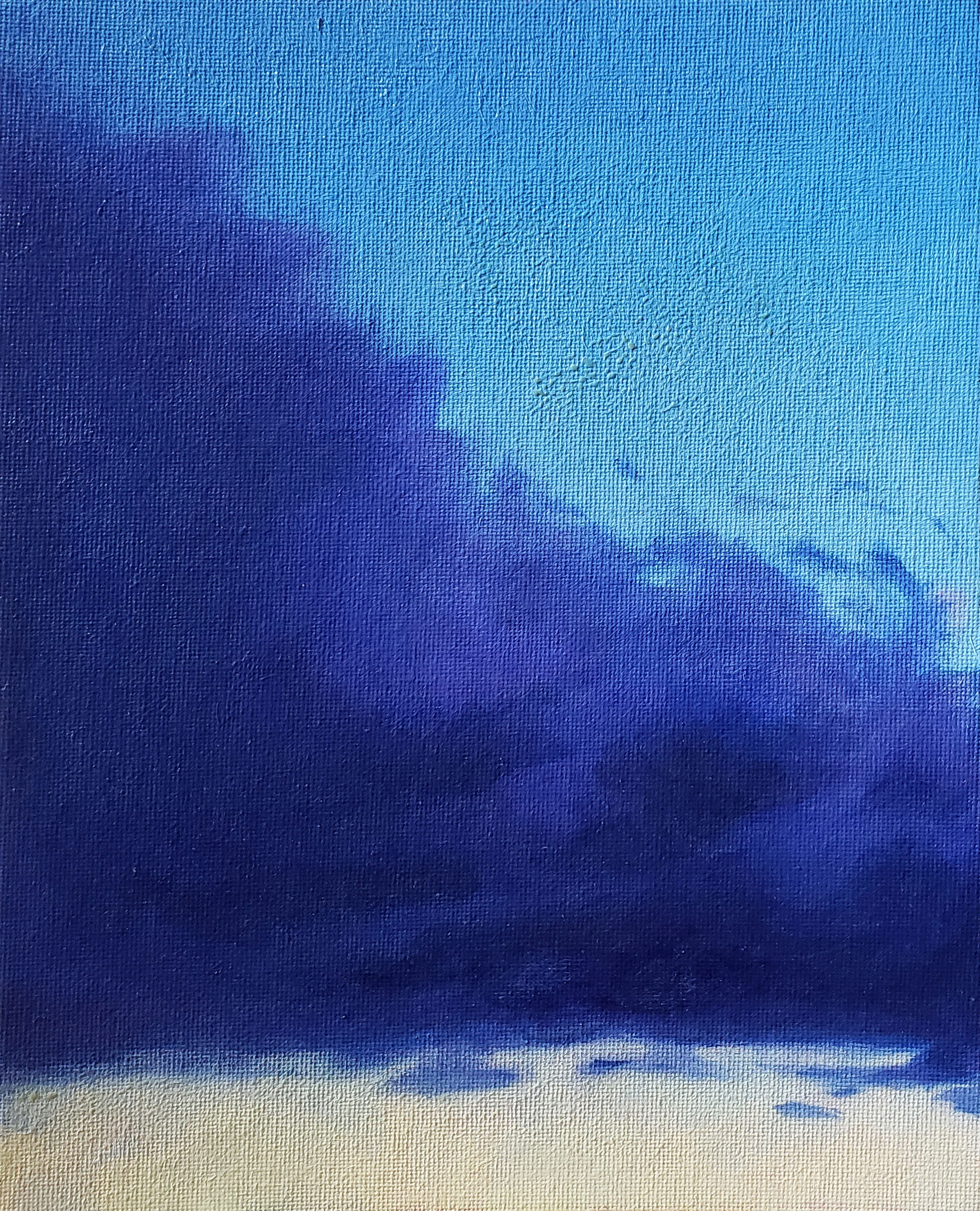 a violet stormcloud against a deep blue green and yellow sunset sky