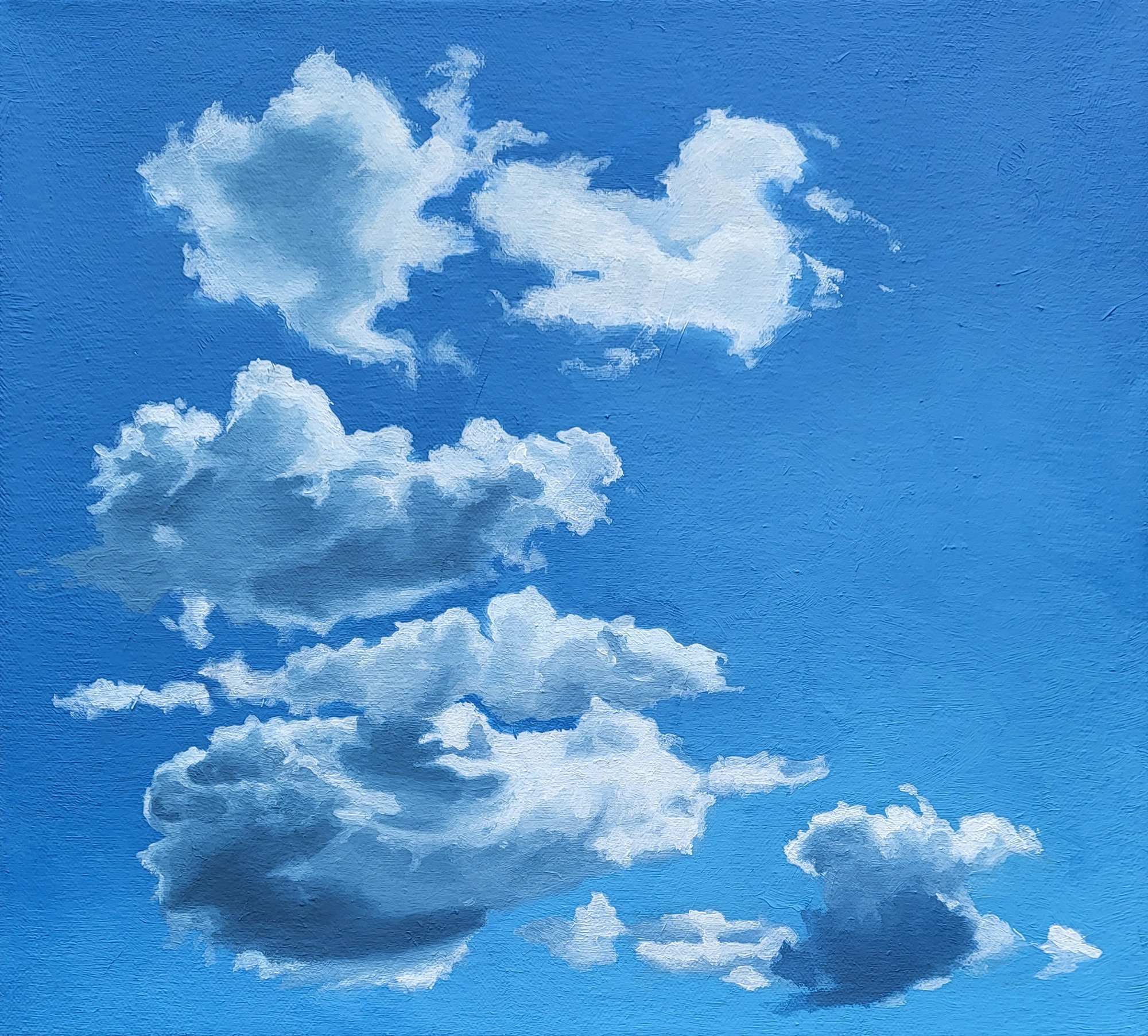 bright white sunlit clouds against a deep blue sky