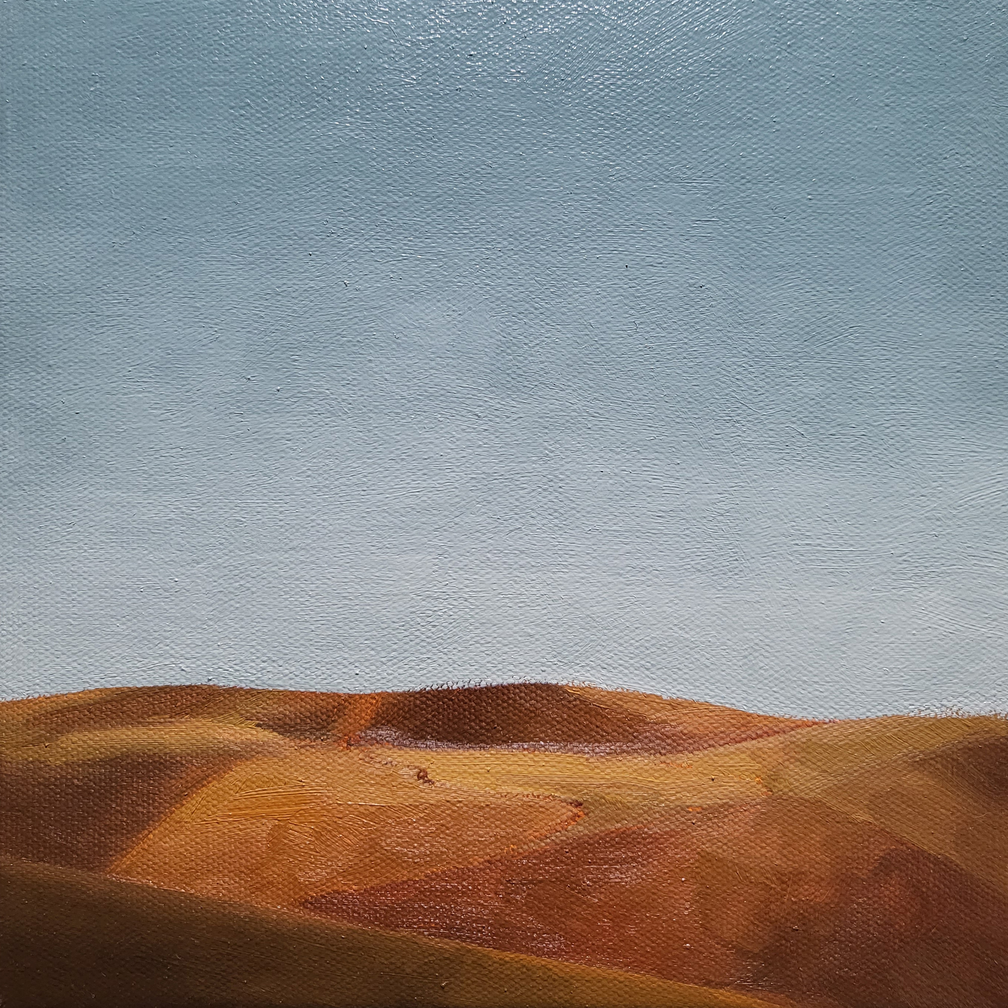 gently sloping golden hills and a light blue sky