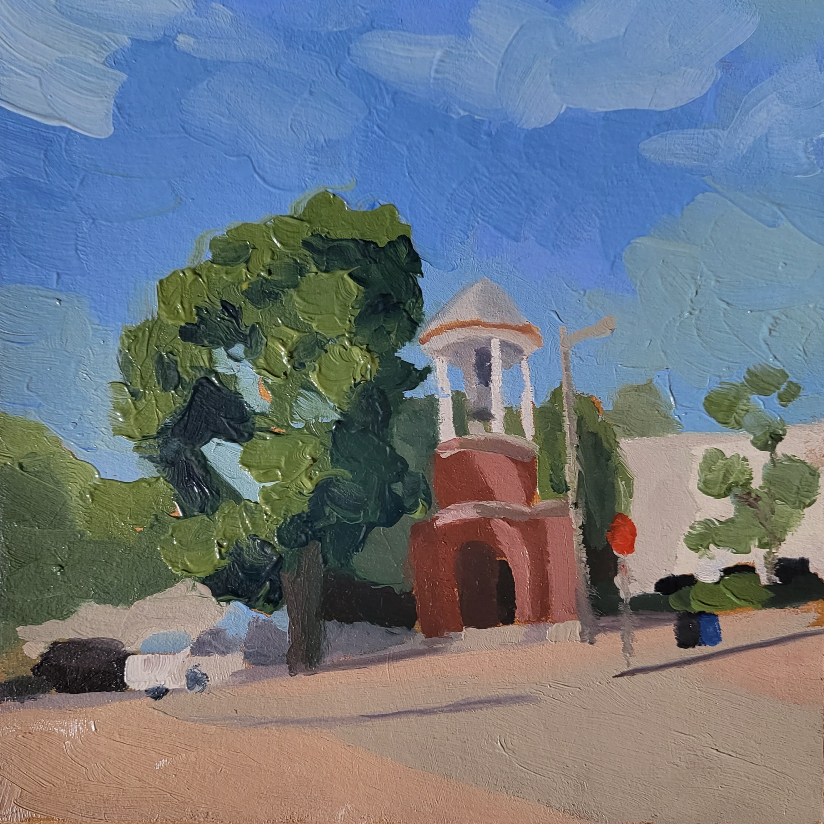 old bell tower on a brick-lined street on a sunny day