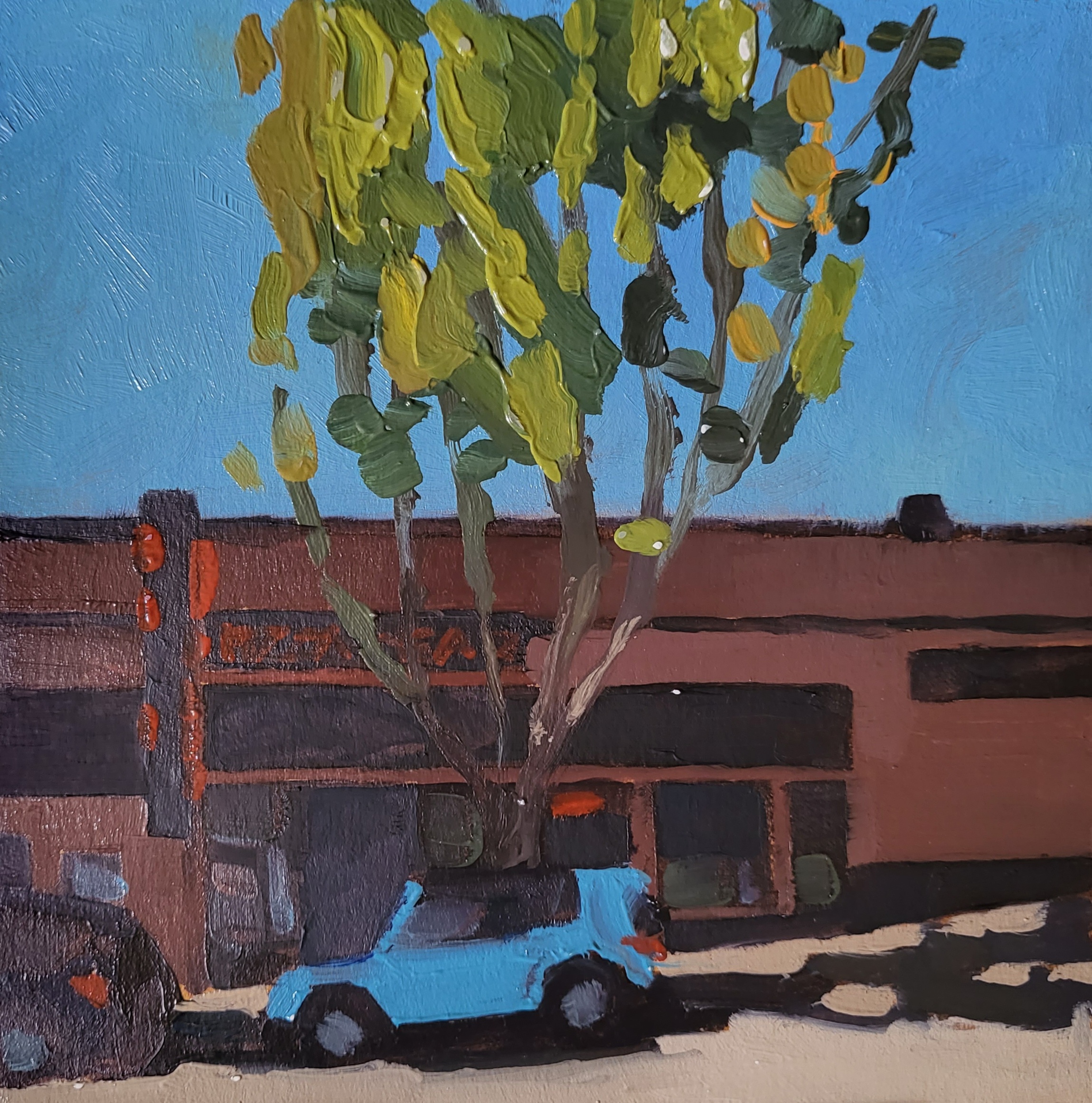 tree and blue car in front of brick front restaurant with neon sign